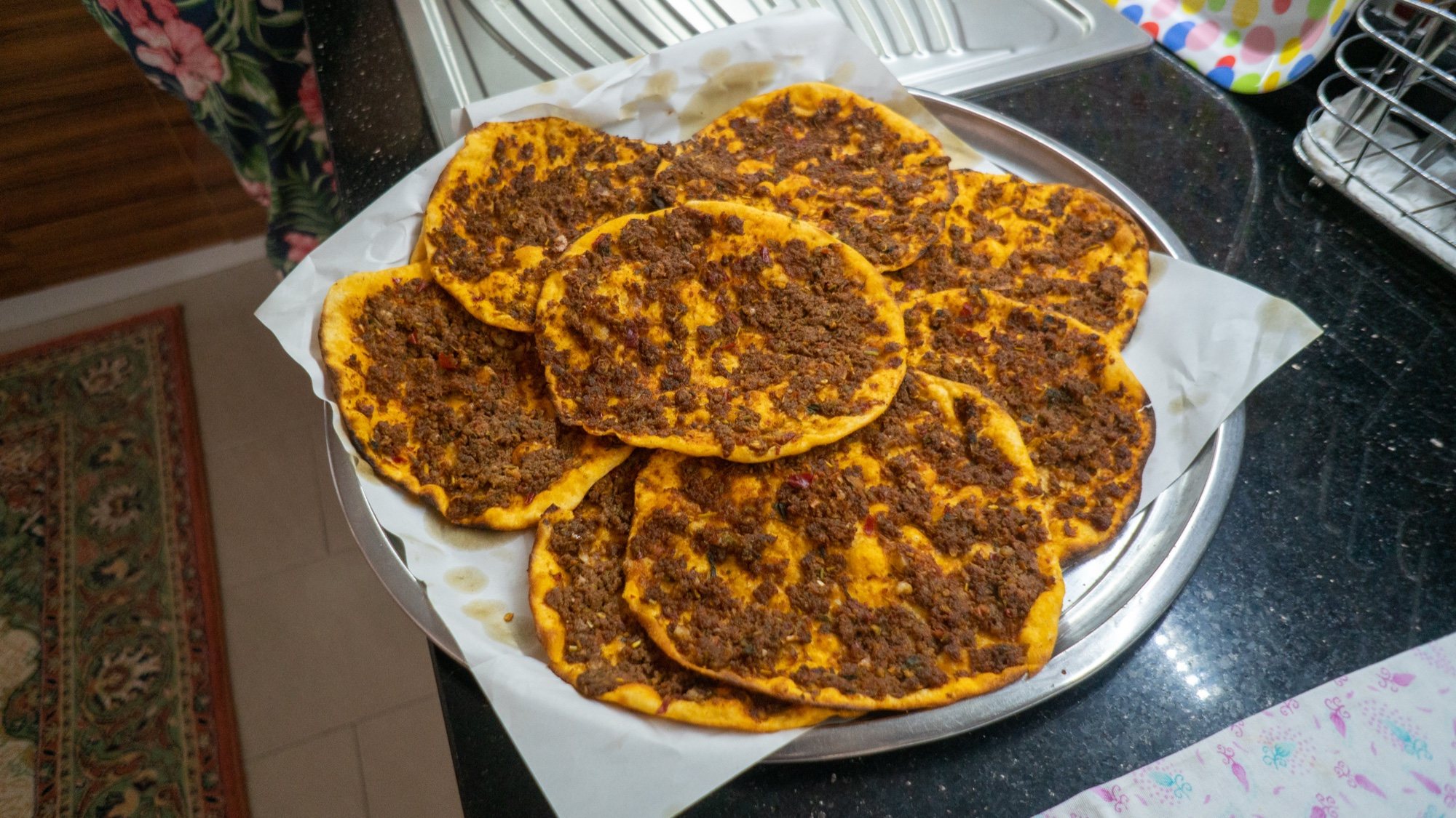 Tepside kâğıt üzerine dizilmiş küçük boy, ince hamurlu kıymalı lahmacunlar